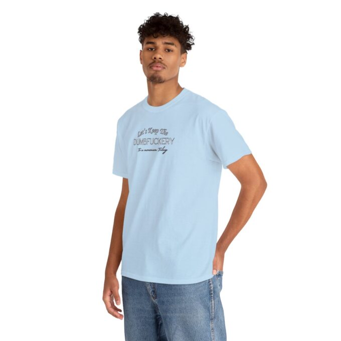 A man in blue shirt and jeans standing next to a wall.