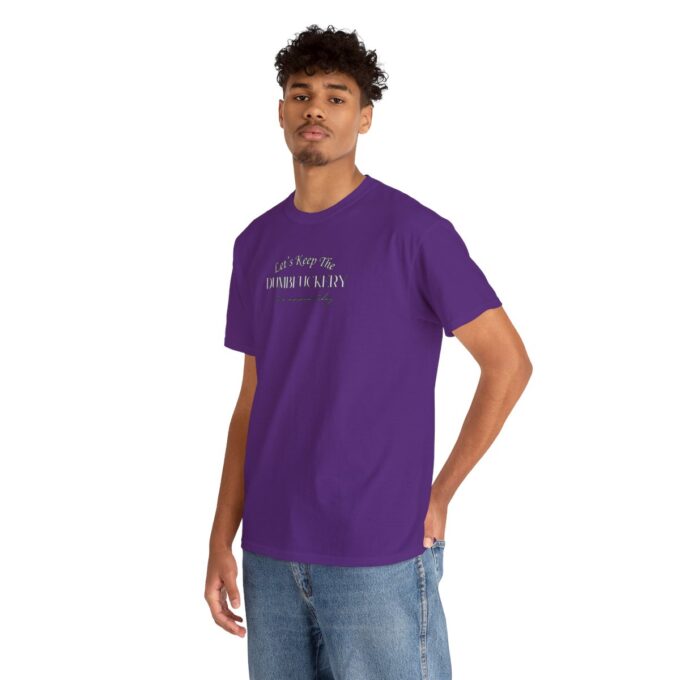 A man in purple shirt and jeans standing next to a wall.