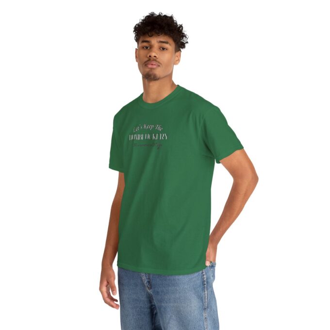 A man in green shirt and jeans standing next to a wall.