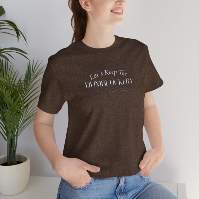 A woman sitting on the ground wearing jeans and a t-shirt.