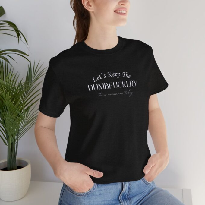 A woman sitting on the ground wearing jeans and a t-shirt.