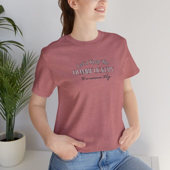 A woman is sitting on the ground wearing jeans and a t-shirt.