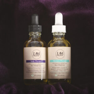 Two bottles of cbd oil sitting on a purple cloth.